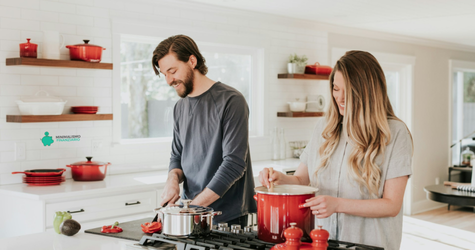 Una coppia che cucina insieme in una cucina accogliente, condividendo un momento gioioso e intimo. L'illuminazione calda e la semplice preparazione della cena creano un'atmosfera rilassata e invitante, evidenziando un appuntamento romantico e economico a casa.